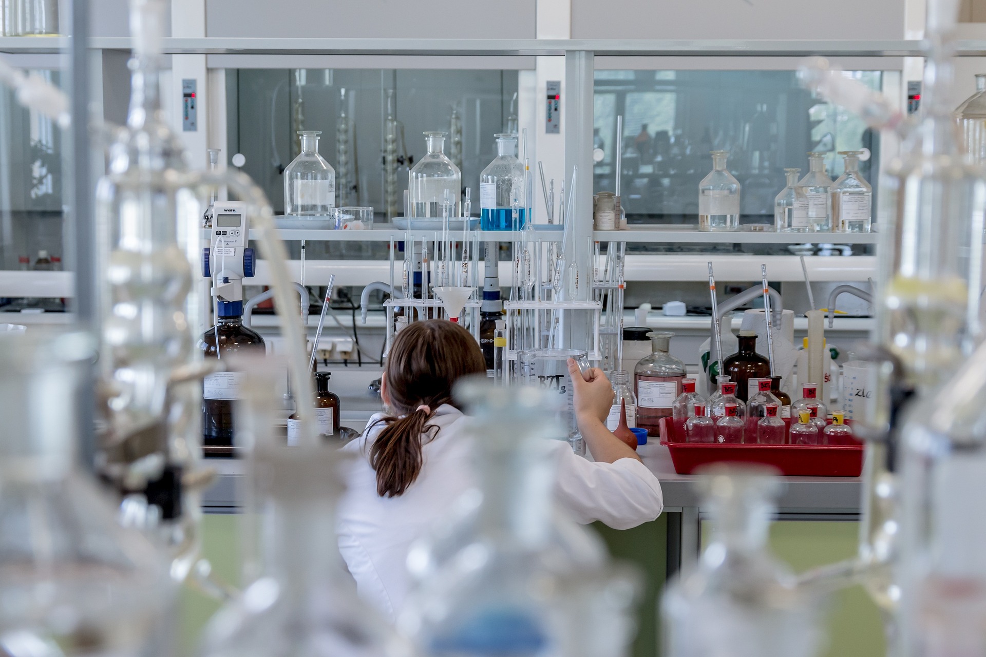 diverse team of scientists and AI researchers working together in a modern lab with computer screens showing research data, blue and green color scheme